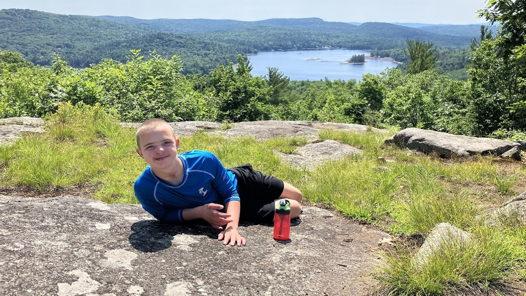 Lucas laying down on the top of a mountain