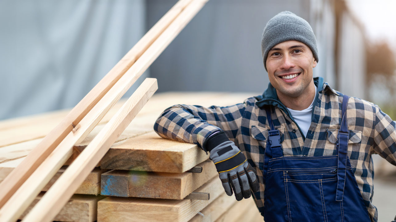 Young male worker in timber warehouse