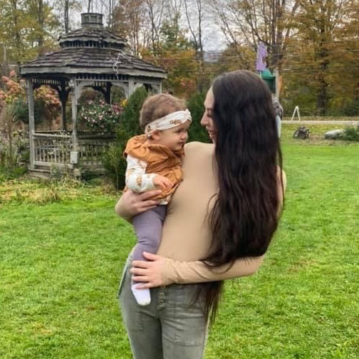 Kearstyn holding a small child outdoors.