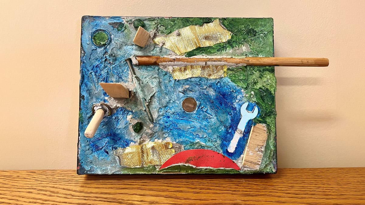 Artwork by Reid displayed on a wooden table.